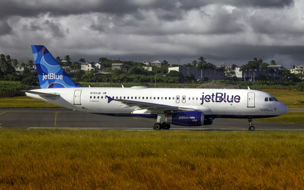 a jet blue airplane is on the runway - JetBlue offers free in-flight Wi-Fi on all flights to all passengers